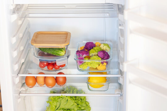 Fresh vegetables in glass containers are on the shelves in the refrigerator. Home order concept