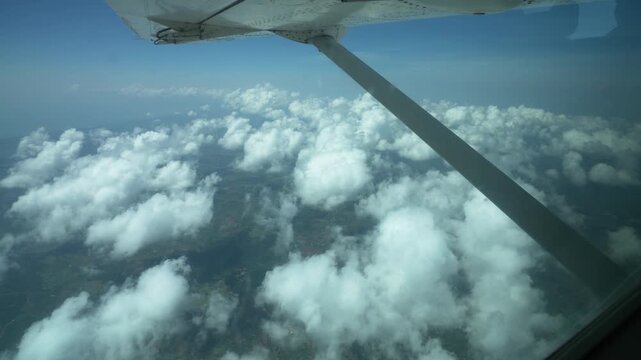 小型機の窓から見下ろす積雲と大地、アフリカ上空の遊覧飛行（Small Aircraft Window View Over Clouds, Uganda Africa）