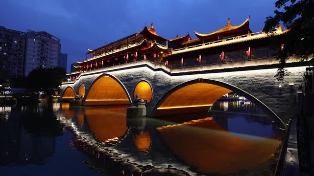View of Anshun Bridge illuminated at night over the Jin River in Chengdu, Sichuan, China.