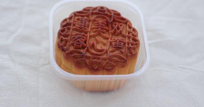 Traditional Chinese sweet dessert for celebrating the Chinese mid autumn festival.Chinese words mean: Two egg yolks white lotus seed paste mooncake.	
