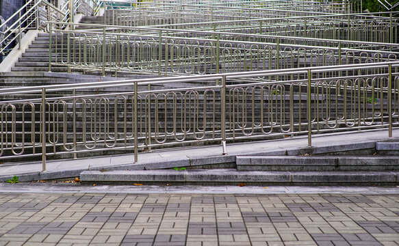 Polished Metal Railings Form Complex Queueing System on Urban Stairs and Ramps