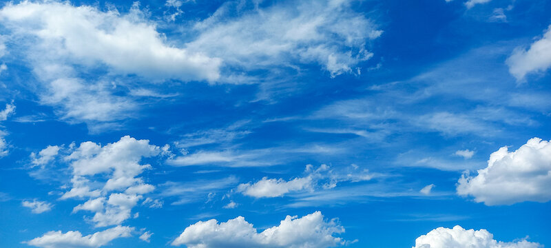 Vibrant Blue Sky with Fluffy White Clouds on a Sunny Day