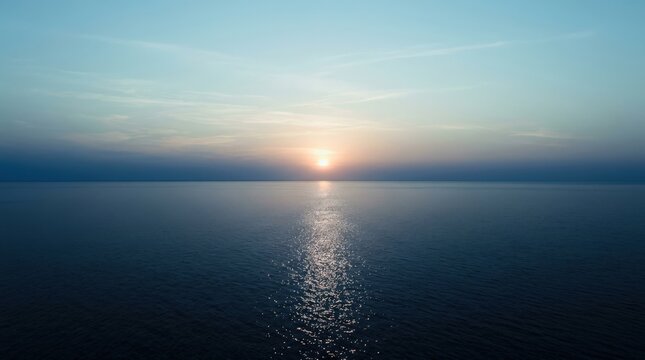 Low sun reflecting across a calm blue ocean horizon, minimalist seascape photography, deep navy water fading to pale cyan sky, sparkling silver path of light, low contrast, serene open composition and