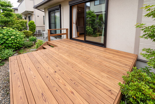 掃き出し窓につながる明るい木目のウッドデッキがある戸建て住宅