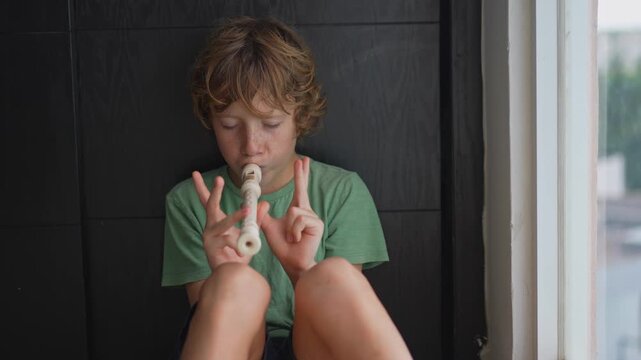 A little boy learns to play the flute at home, practicing with focus and enthusiasm in a cozy, warm setting. A charming scene of early musical exploration, creativity, and childhood growth.