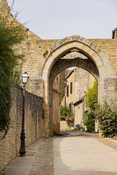 Historic stone gateway opening onto a narrow village lane, Yonne, Montr&eacute;al, France