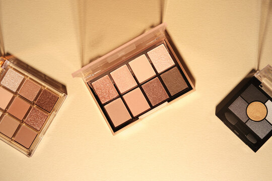 Three makeup palettes with neutral shades displayed on a light background