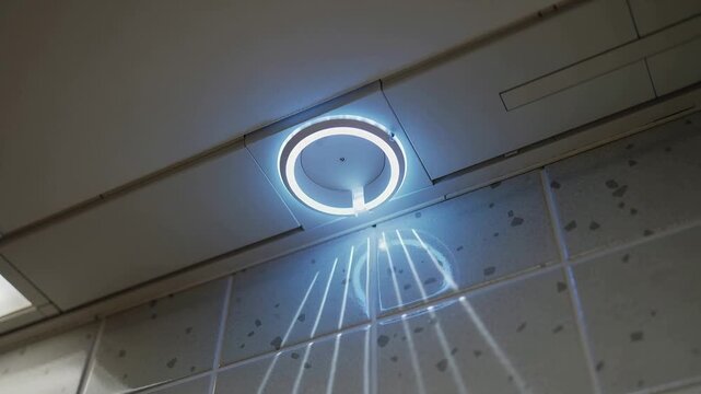 Changing LED ring light shifting purple to blue and casting halo and streaks onto tiled wall