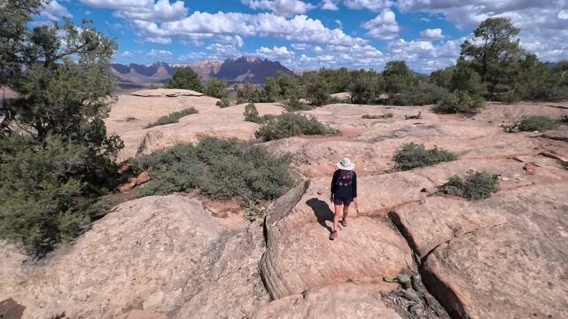 Senior woman hikes peacefully on Gander Trail, surrounded by breathtaking views of Gooseberry Mesa and Zion National Park.