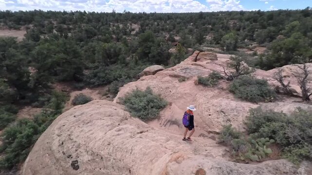 Enjoy breathtaking aerial views of a mature woman hiking through the beautiful terrain of Gooseberry Mesa in Utahs Dixie National Forest.