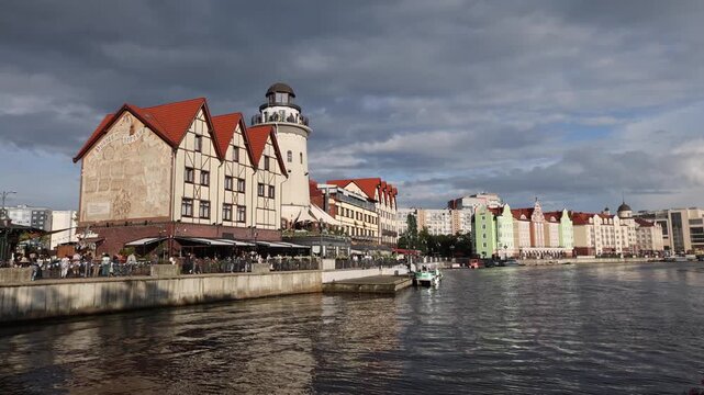 View of the Fisherman's Village with its distinctive half-timbered architecture and lighthouse tower along the Pregolya River in Kaliningrad, Kaliningrad Oblast, Russia.