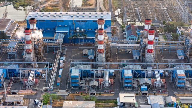 Aerial view of a large industrial power plant with tall chimneys and blue buildings in Semarang, Central Java, Indonesia.