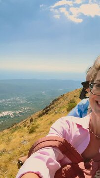 two happy women tourist taking selfie enjoying amusement attraction roller-skating along mountain top view summit Mount. girl traveler looking out scene bay blue sea mountains day sky. vertical video