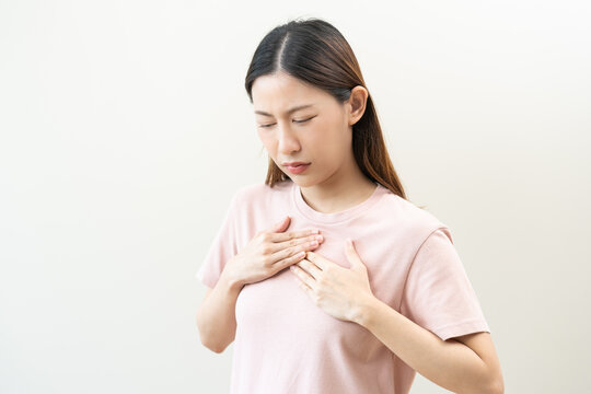 Acid reflux disease, suffer asian young woman have symptom gastroesophageal, esophageal, stomach ache and heartburn pain hand on chest from digestion problem after eat food, Healthcare medical concept