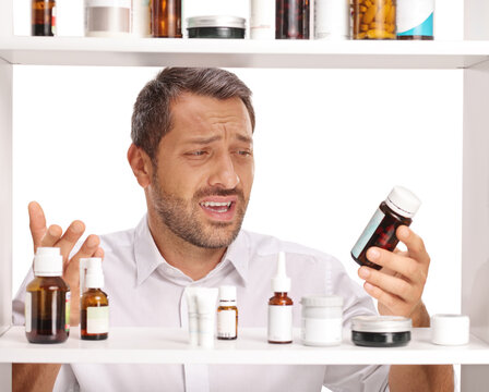 Man looking confused with a medicine bottle