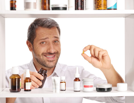 Man holding a single softgel capsule pill