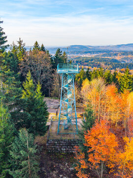 Slovanka Lookout Tower stands tall in the Jizera Mountains, surrounded by vibrant autumn colors. Visitors can enjoy panoramic views of the beautiful fall landscape and tranquil nature.