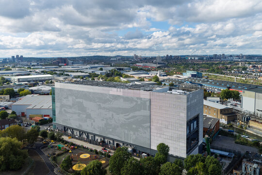 Aerial view of a modern data center building surrounded by industrial warehouses and urban infrastructure in the United Kingdom.