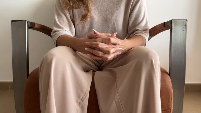 Mujer nerviosa entrelazando las manos durante terapia psicol&oacute;gica
