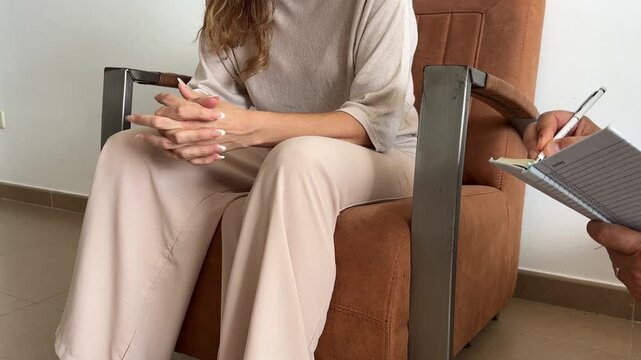 Mujer sentada en terapia mientras el terapeuta toma notas