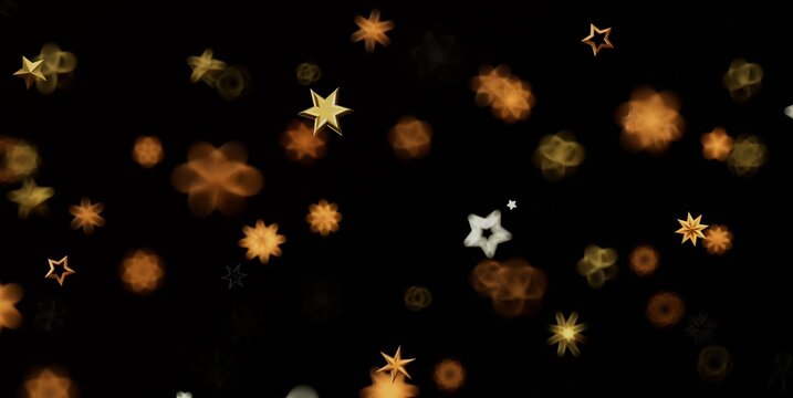 Sparkling golden stars and bokeh create a festive and magical abstract background.