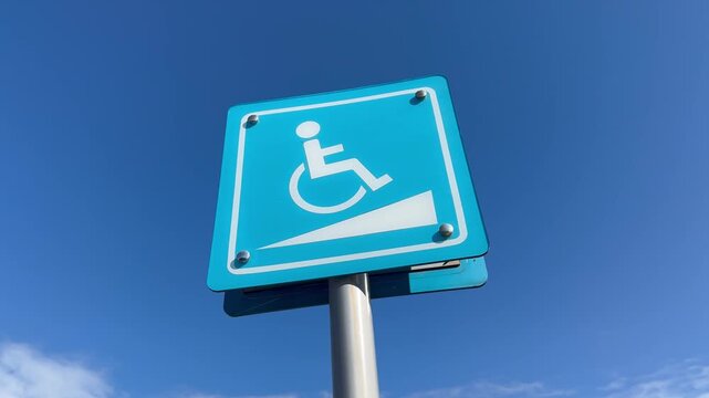 Right-to-left panning shot from disabled parking sign to wheelchair ramp accessibility sign.