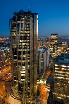 Aerial view of the iconic Torres KIO skyscrapers illuminated at twilight, featuring their inclined architecture, overlooking the city skyline of Madrid, Community of Madrid, Spain.