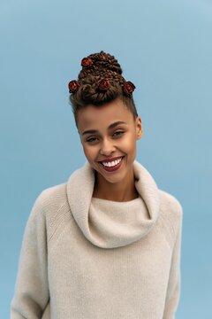 Full length portrait of smiling woman with braided bun and rose details wearing a cowl neck sweater for fashion editorial, profile, and lifestyle background use
