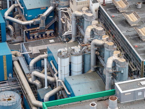 Aerial view of Klarwerk Ruhleben featuring complex industrial piping, large cylindrical tanks, and metal structures at the wastewater treatment plant in Berlin, Berlin, Germany.