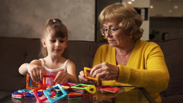 Grandmother and granddaughter playing magnetic blocks together