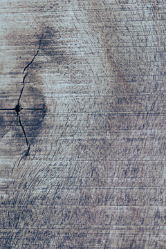 Aged wood surface showing deep grain lines, a distinctive crack, and a visible knot, providing a rich, textured background for various design projects