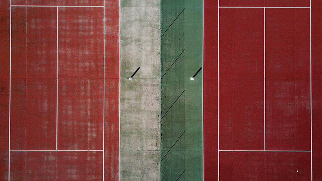 Aerial view of tennis courts with red and green surfaces in Jougne, Bourgogne-Franche-Comte, France.