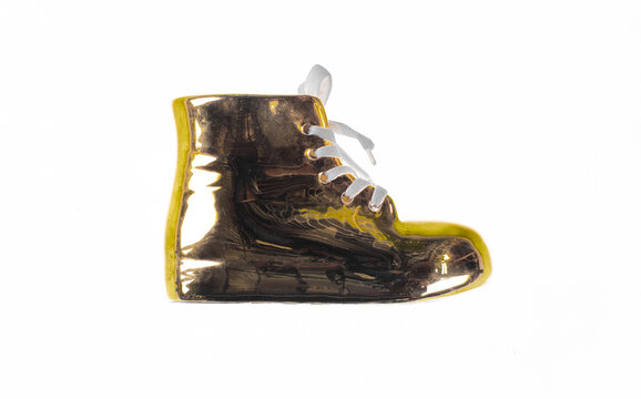 Golden shoe with a lace, isolated on a white background.