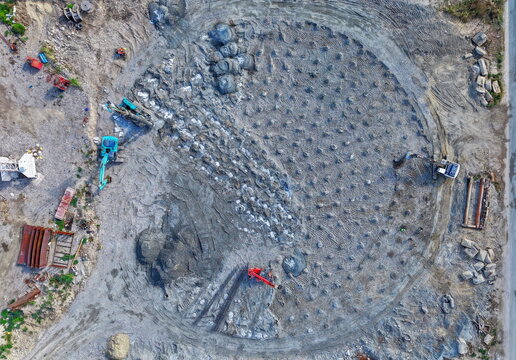 Aerial view of assembly-making of a refinery fuel tank with heavy machinery and excavators on a construction site in Kovin, Vojvodina, Serbia.