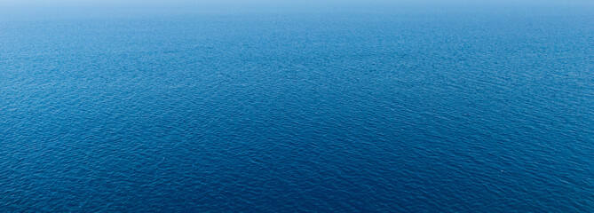Full frame surface of a deep blue sea covered with fine wind ripples in a wide panoramic crop, natural water texture without horizon, concept of ocean background, calm and summer freshness © daily_creativity