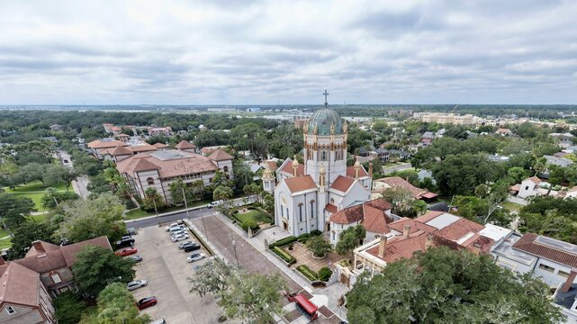 Aerial view of the Memorial Presbyterian Church with its distinctive copper dome and red tile roofs surrounded by the historic urban landscape of St. Augustine, Florida, United States.