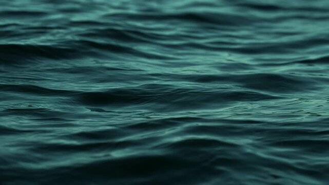 Deep blue ocean water moving with gentle waves creating a calming and meditative natural abstract background in a dark moody tone