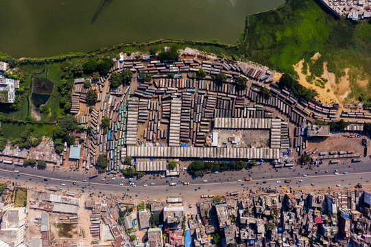 Aerial view of Gabtoli Bus Terminal with rows of parked buses, corrugated roof structures, and surrounding urban density in Dhaka, Dhaka Division, Bangladesh.