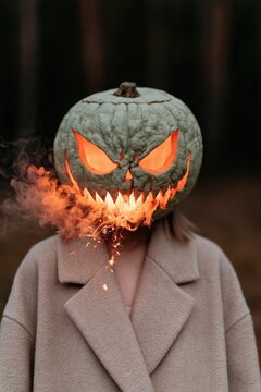 Green carved pumpkin head halloween portrait with jagged teeth and burning spark effects for unsettling poster background and horror design
