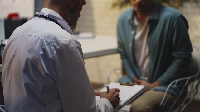 Male patient discusses urinary problems with doctor during health check-up