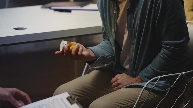 Male patient receives medication bottle, listening to urologist recommendations