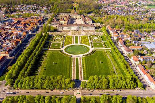 Aerial view of Ludwigsburg Palace with its extensive baroque gardens, manicured lawns, geometric flower beds, and surrounding urban landscape in Ludwigsburg, Baden-Wurttemberg, Germany.