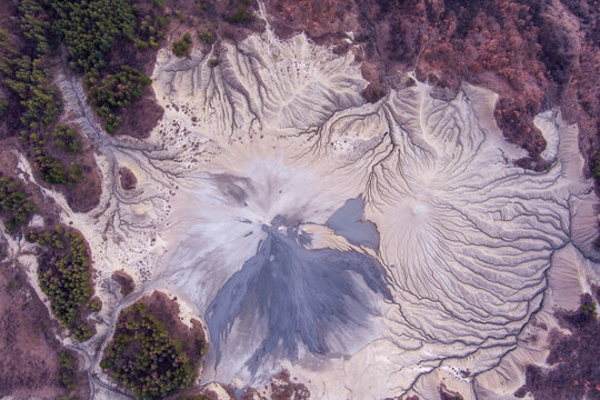 Aerial view of the Mud Volcanoes of Paclele Mari showing intricate grey mud flows and patterns in the landscape of Paclele, Buzau County, Romania.