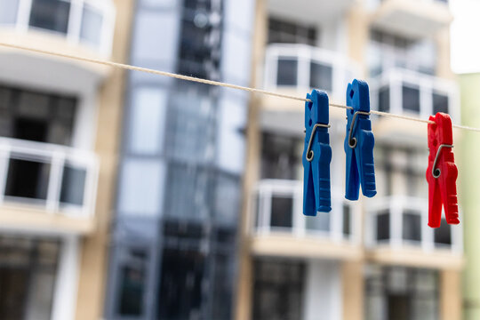 three clothespins hang on rope close-up on balcony