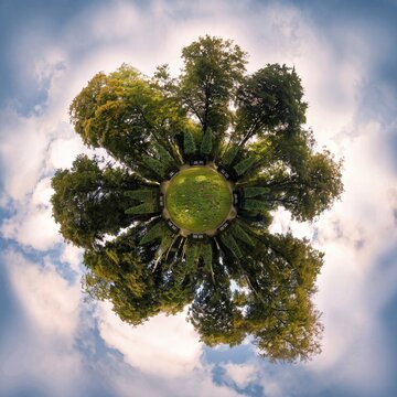 360-degree tiny planet panorama of a lush green park surrounded by tall trees under a cloudy sky