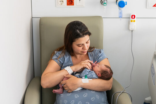 Mother holding newborn baby bonding in hospital