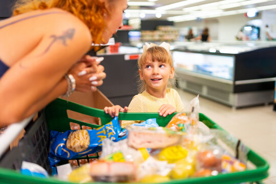 Mother and daughter grocery shopping, refugee family adapting to new life in spain