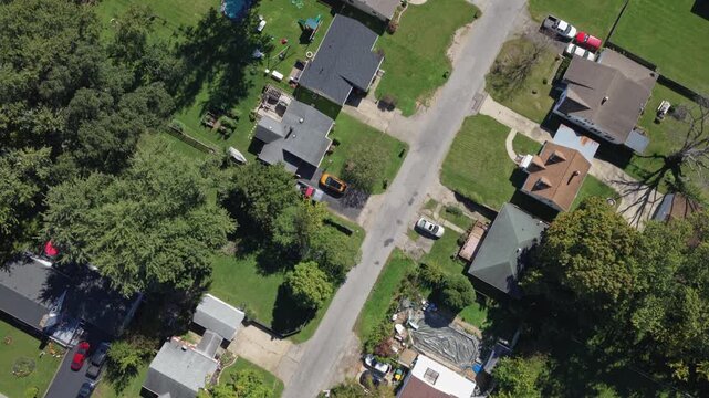 Drone aerial view of suburban rural neighborhood homes, houses,  neighbors, and family residential units in housing market by central Ohio city town Springfield, OH by countryside roads and streets 4k