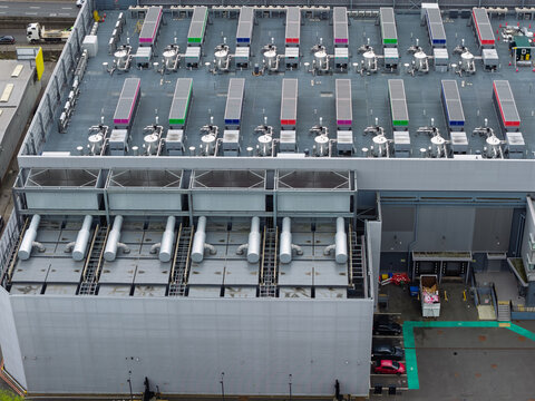 Aerial view of a large data center with rows of industrial cooling units and HVAC systems on the rooftop in the United Kingdom.