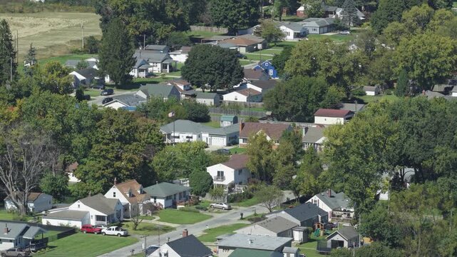 Drone aerial view of suburban rural neighborhood homes, houses,  neighbors, and family residential units in housing market by central Ohio city town Springfield, OH by countryside roads and streets 4k